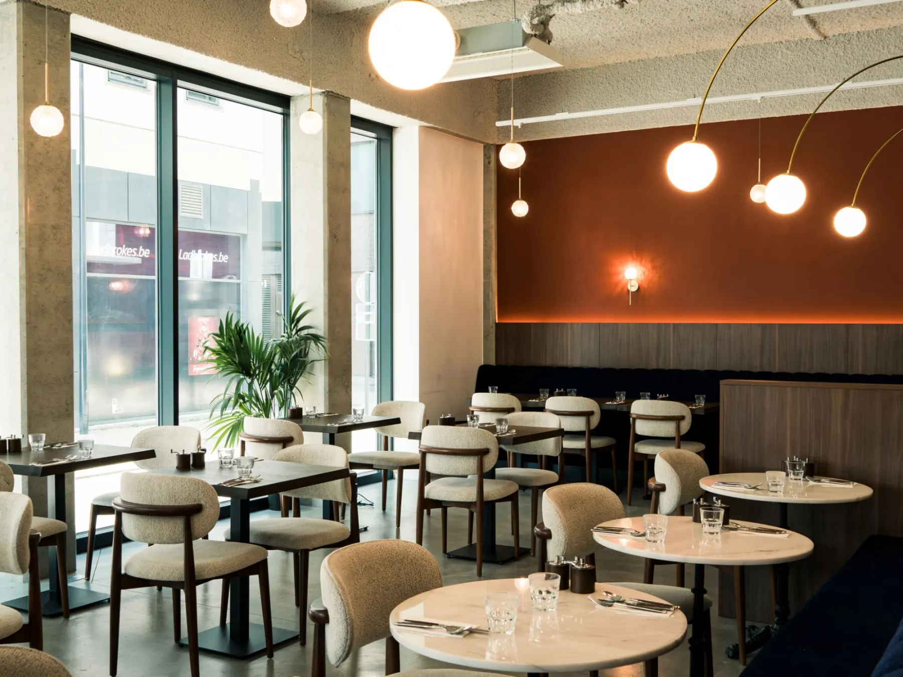 Salle de restaurant avec habillage mural en noyer, chaises et tables sur mesure
