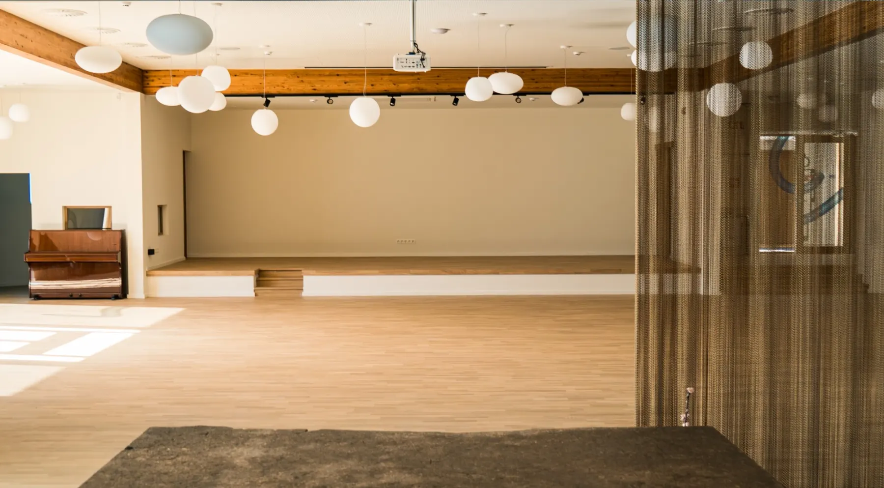 Salle polyvalente avec parquet en chêne et estrade